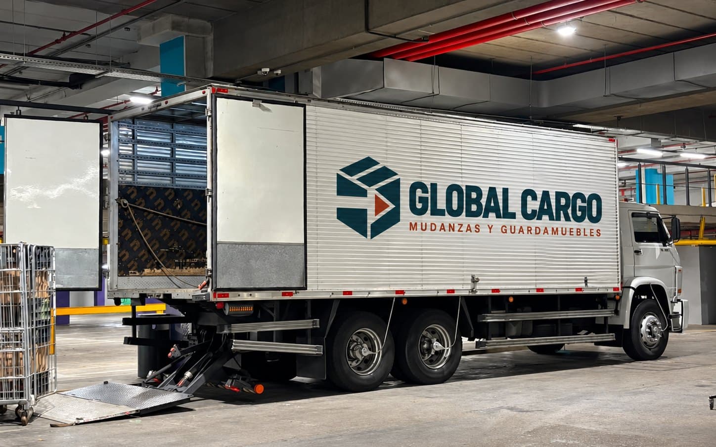 Camión de Global Cargo descargando en la zona de carga de un edificio